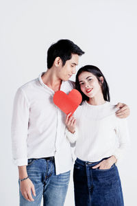 Young couple kissing against white background