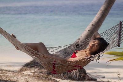 Low angle view of woman sitting on beach