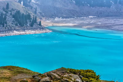 Scenic view of lake and mountains against blue sky