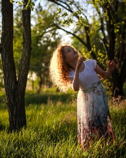 Woman standing by tree on field