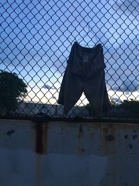 Chainlink fence against cloudy sky