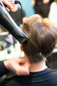 Barber drying hair of man at salon