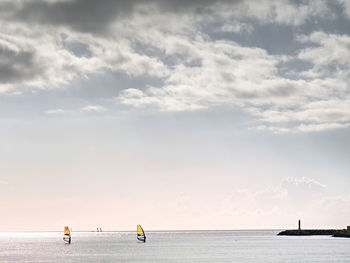 Windsurfer men on a windsurfs. gentle wind blowing, afternoon sun glittering in sea waves