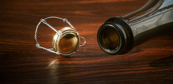 Empty champagne bottle and muzzle close up on wooden surface