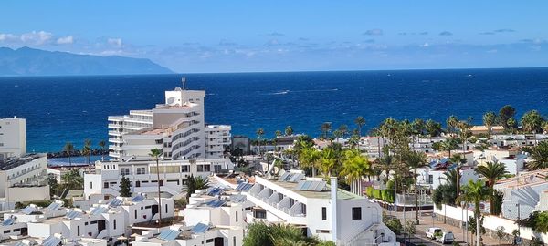 High angle view of townscape by sea against sky