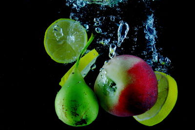 Close-up of water drops on fruit against black background