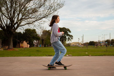 Portrait of teenage girl skateboarding