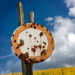 Low angle view of rusty metal pole against sky