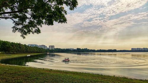 Scenic view of river by city against sky