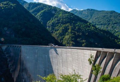 Scenic view of dam and mountains against sky