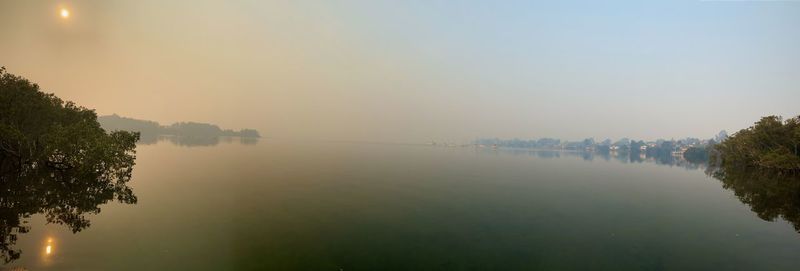 Scenic view of lake against sky during foggy weather