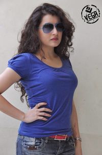 Portrait of young woman wearing sunglasses standing against wall