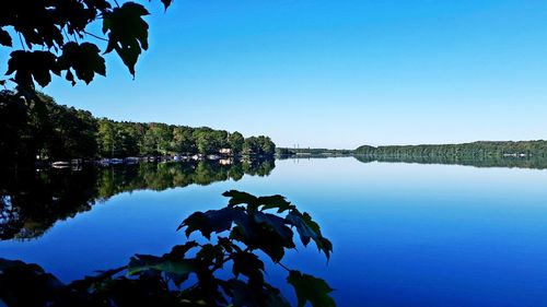 Scenic view of lake against clear blue sky