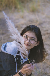 Portrait of young woman holding plant