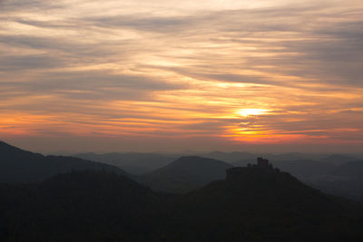 Scenic view of mountain against cloudy sky during sunset