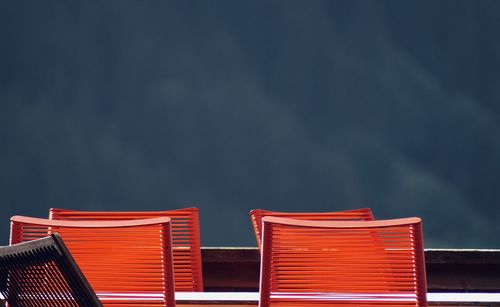 Low angle view of red chairs against the horizon