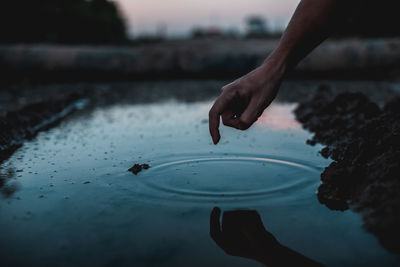 Close-up of hand touching water