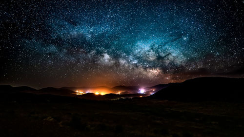 Scenic view of mountains against milky way sky at night