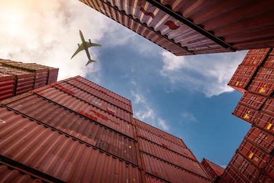 Airplane flying above container logistic. cargo and shipping business. container ship for export.