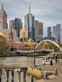 Scenic view of riverfront, bridge and buildings in the city