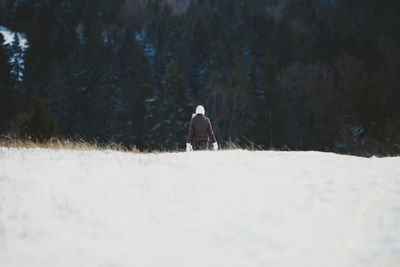 Rear view of woman on snow covered landscape 