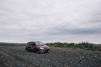 Car on road by land against sky