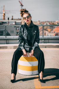 Full length of young woman sitting outdoors