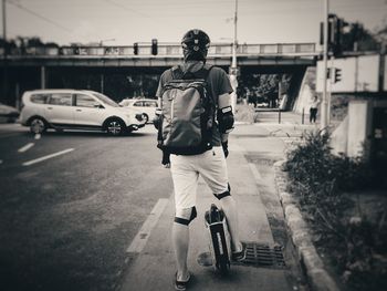 Rear view of man cycling on road