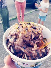 Close-up of hand holding ice cream in bowl