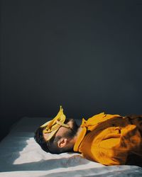 Man sleeping on bed against black background