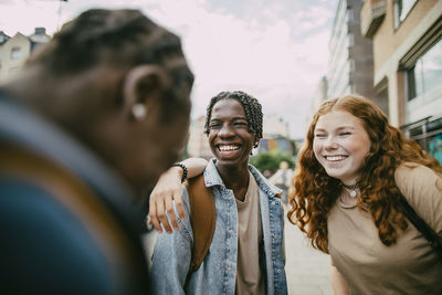 Happy multiracial teenagers enjoying with friends in city