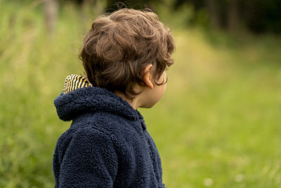 Side view portrait of boy on field