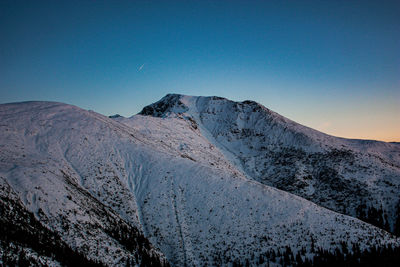 Scenic view of snowcapped mountains against clear blue sky