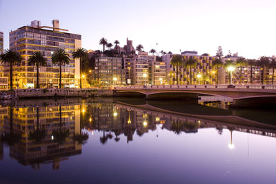 Reflection of illuminated buildings in river at night