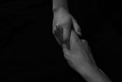 Close-up of hands against black background