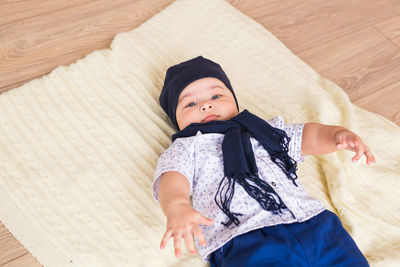 High angle view of cute baby lying on floor at home