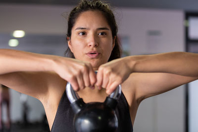 Portrait of young woman exercising in gym