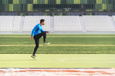 Young man warming up at sports field