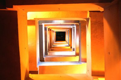 Directly below shot of spiral orange steps at night