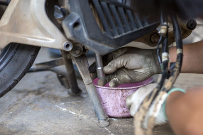 Close-up of hands working on motorcycle