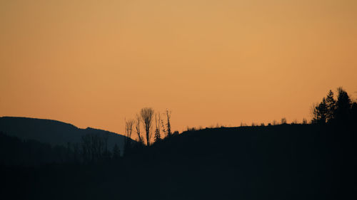 Scenic view of silhouette mountains against orange sky