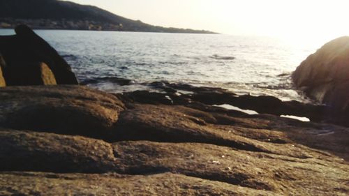Scenic view of rocks on beach against sky