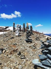 Stack of rocks on shore against blue sky