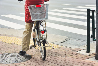 Man crossing bicycle on street
