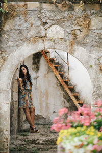 Portrait of woman standing against wall