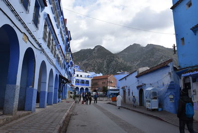 People on street amidst buildings in city