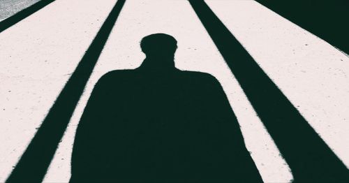 Shadow of person on footpath