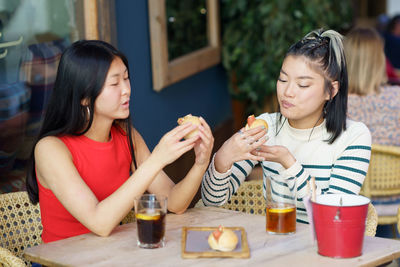 Smiling friends having food at restaurant