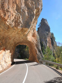 Road by rock formation against mountain