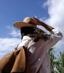 Rear view of woman standing against sky